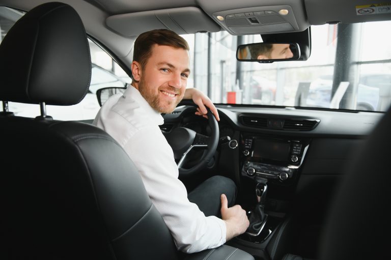 kierowca Free Now uśmiecha się do pasażera w trakcie przejazdu taxi z firma Gocab